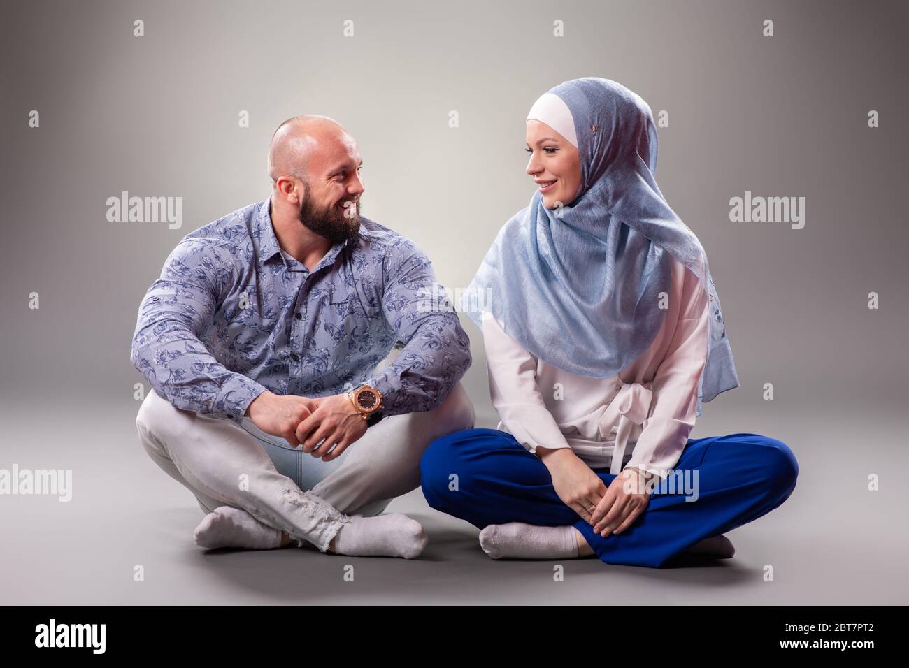 Felice coppia innamorata che posa su sfondo grigio. Foto Stock