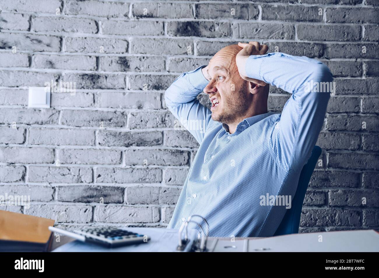 Preoccupato uomo confuso in camicia che lavora in ufficio Foto Stock