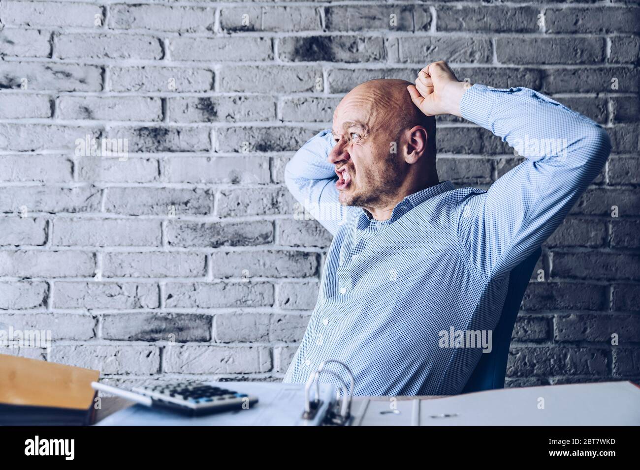 Preoccupato uomo confuso in camicia che lavora in ufficio Foto Stock