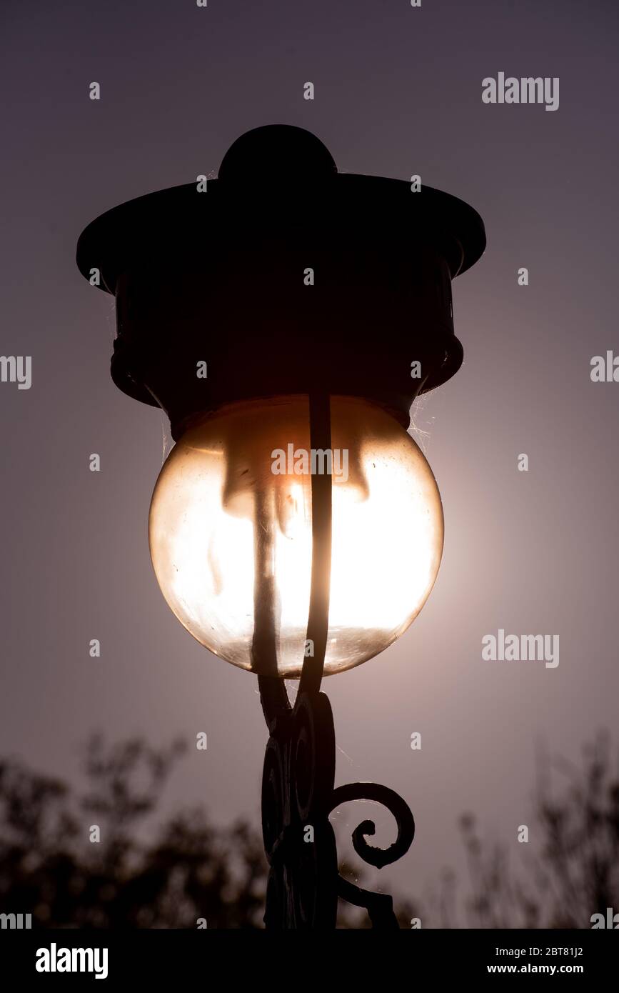 Vecchia lampada streetlight sul Mound illuminato dalla luce del sole dalla stazione di Waverley Edimburgo Foto Stock
