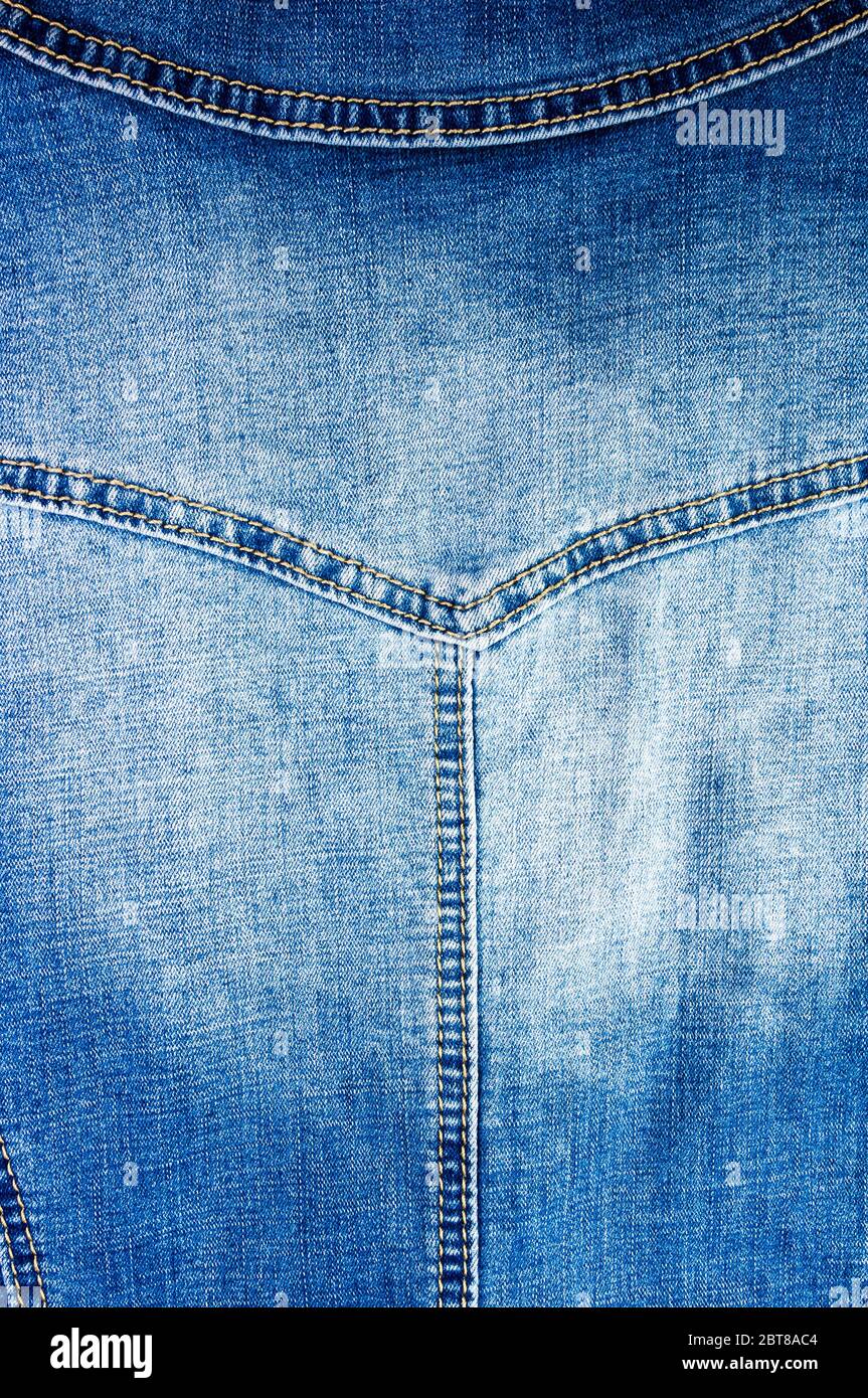 Articoli di abbigliamento stonewashed blue jeans scoloriti tessuto di  cotone texture con cuciture, fibbie, bottoni e rivetti, macro close-up Foto  stock - Alamy