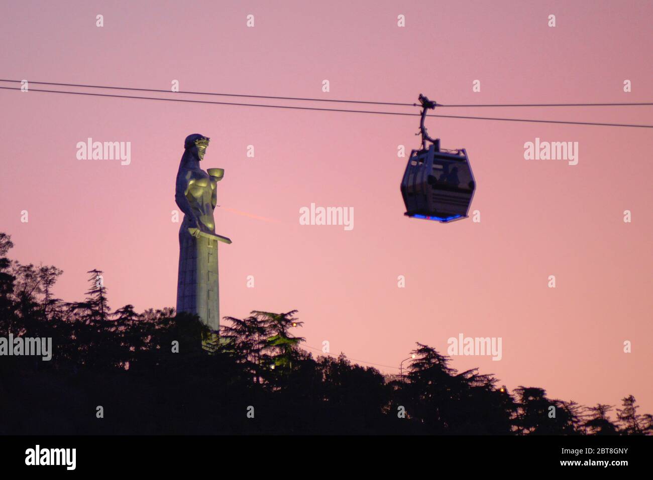 Tbilisi: Tramonto sul monumento Kartlis Deda e funivia, Repubblica di Georgia Foto Stock