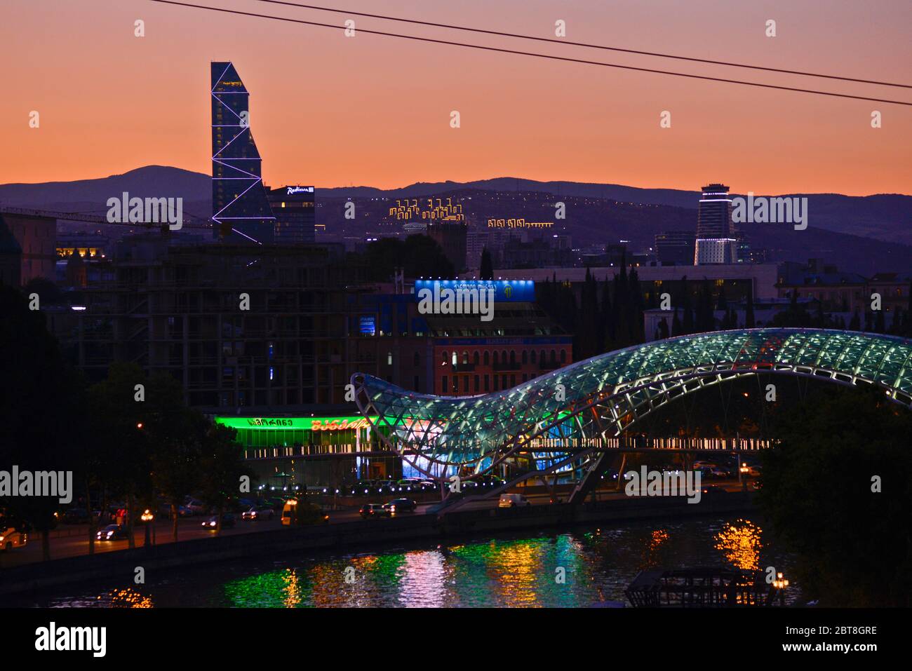 Tbilisi: Tramonto sul Ponte della Pace e sul fiume Kura (Repubblica di Georgia) Foto Stock