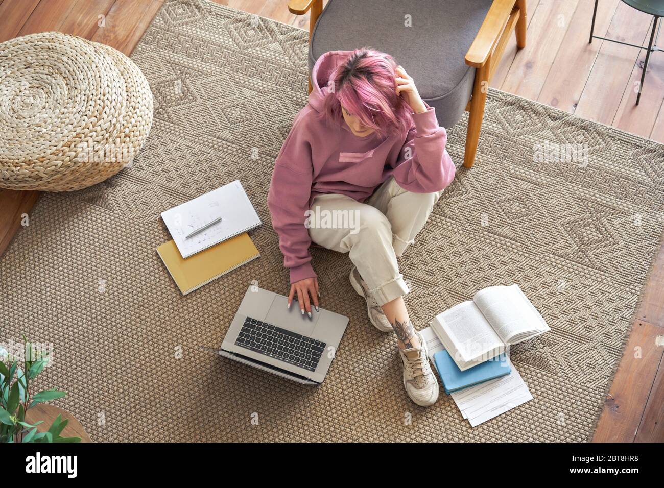 Teen ragazza scuola studente capelli rosa utilizzando il computer portatile sedersi sul pavimento elearning vista dall'alto. Foto Stock