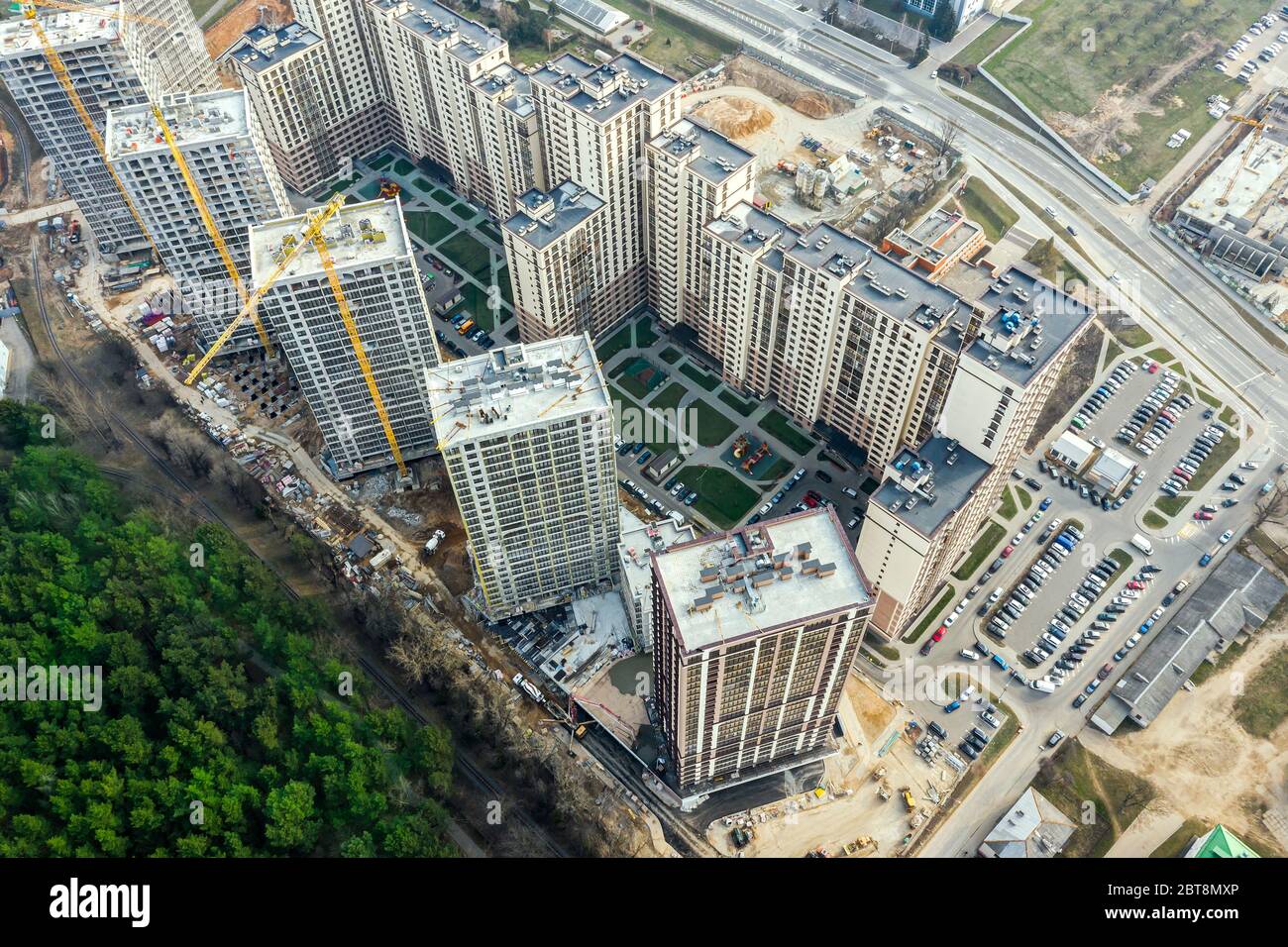 costruzione di un nuovo quartiere residenziale vicino al parco cittadino. gru e altre attrezzature industriali in cantiere. foto lookin drone aereo Foto Stock