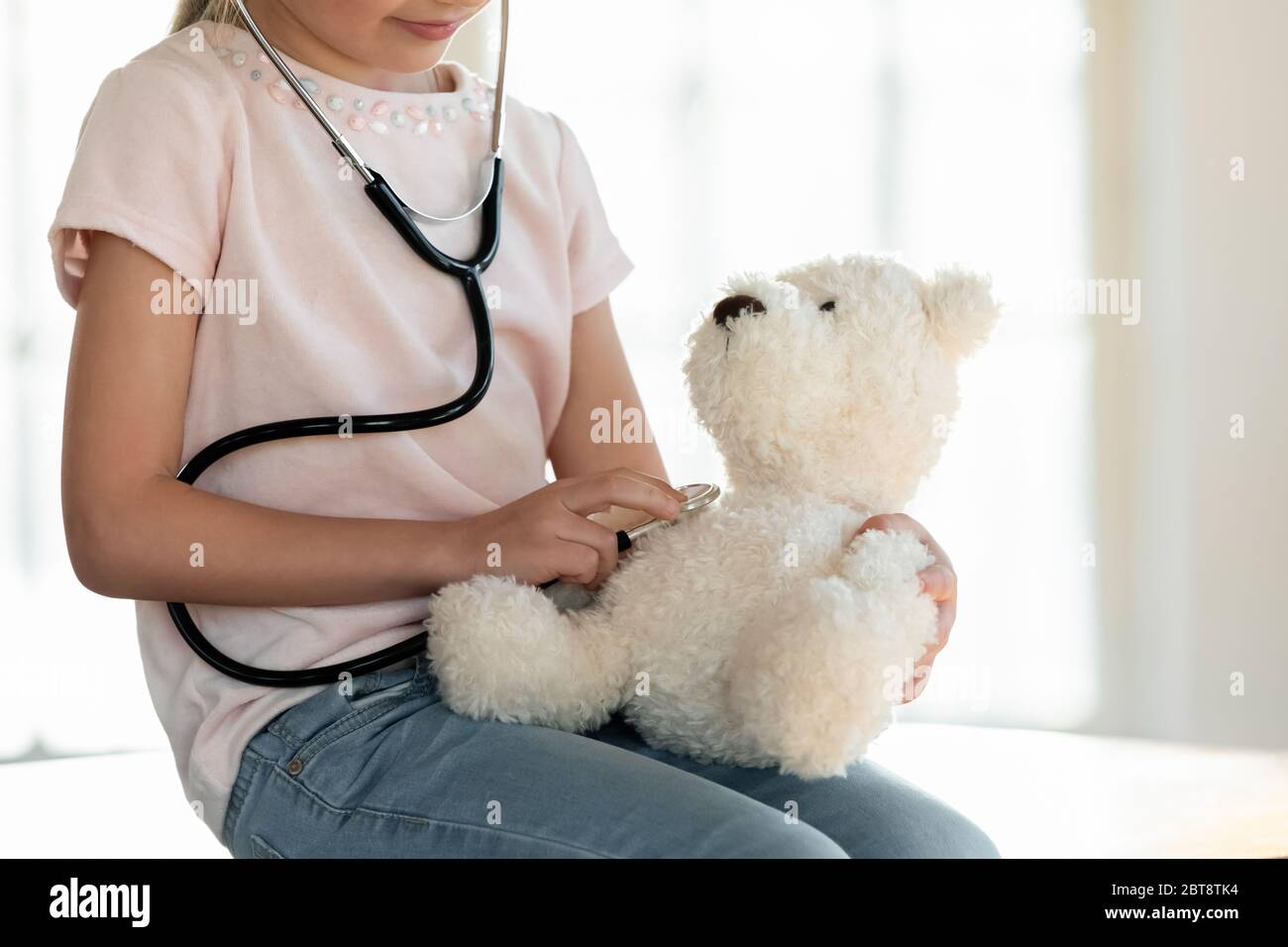 Ragazza piccola cura giocare gioco medico con peluche giocattolo Foto Stock