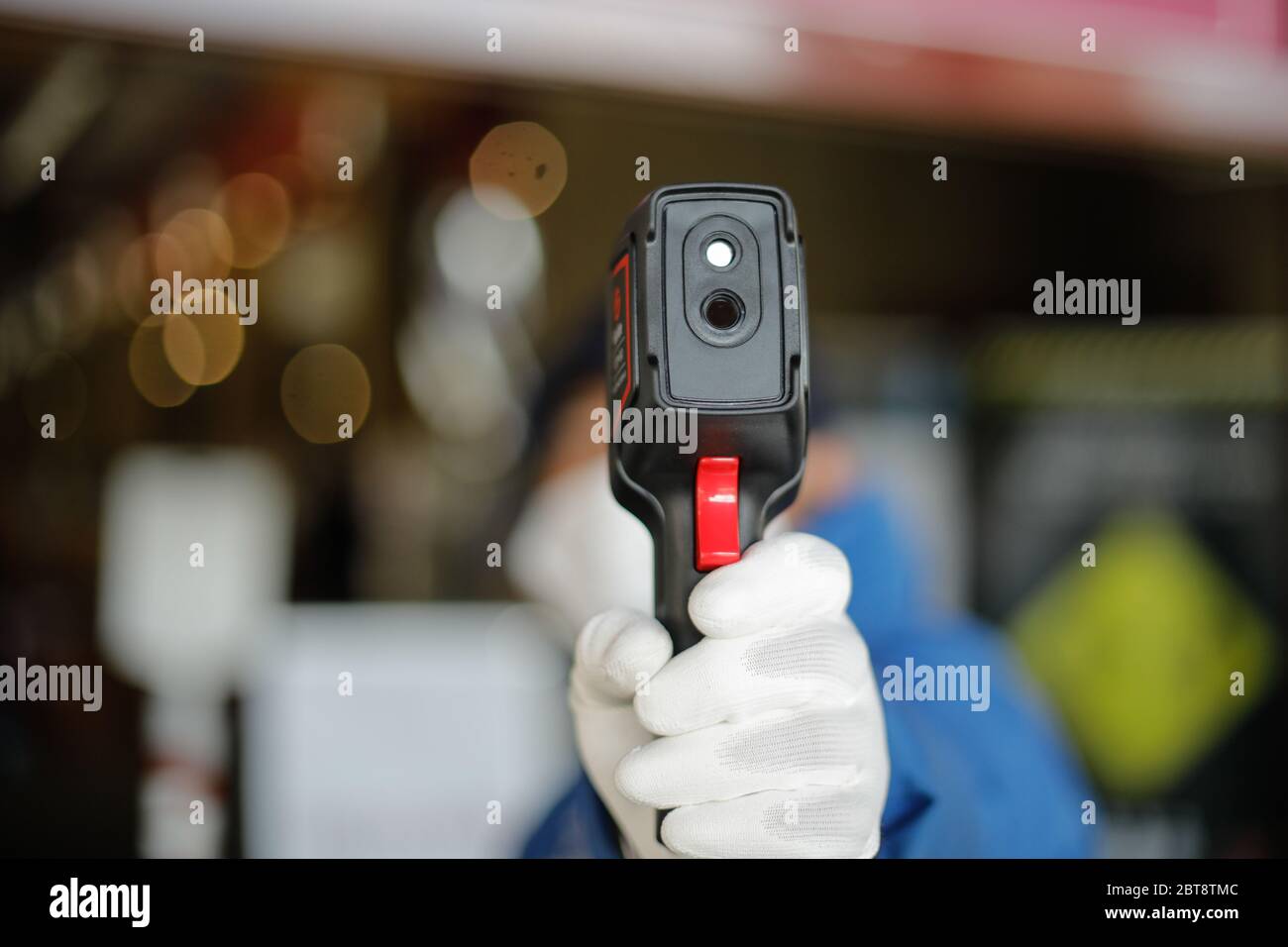 Bucarest, Romania - 7 maggio 2020: Dettagli con un negozio guardia di sicurezza clienti termoscansione prima di entrare nel negozio durante l'epidemia covid-19. Foto Stock
