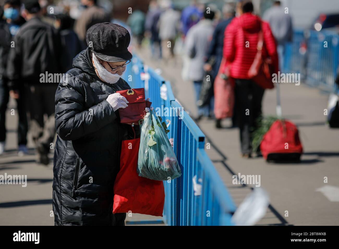 Bucarest, Romania - 16 aprile 2020: Gli anziani che indossano maschere protettive fanno il loro shopping in un mercato aperto occupato a Bucarest durante l'epidemia di covid-19 Foto Stock