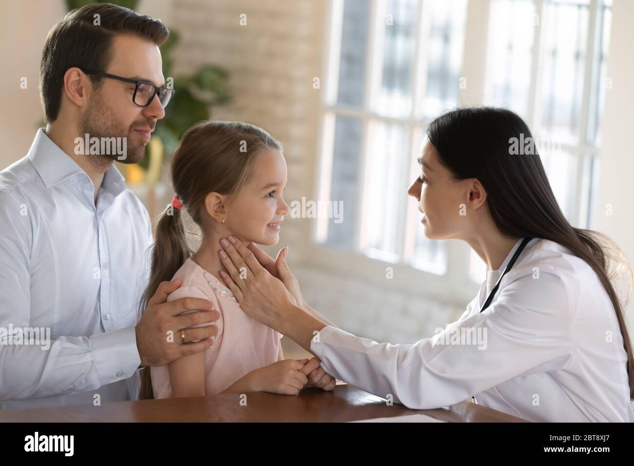 Il medico femminile esamina il paziente piccolo del bambino alla consultazione Foto Stock