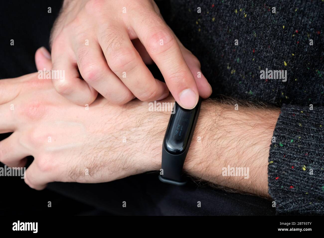 bracciale fitness nero sul guardaroba della mano del ragazzo. Concetto di moderni gadget per lo sport e la salute. Giovane ragazzo che tocca la smart band dopo aver corso Foto Stock