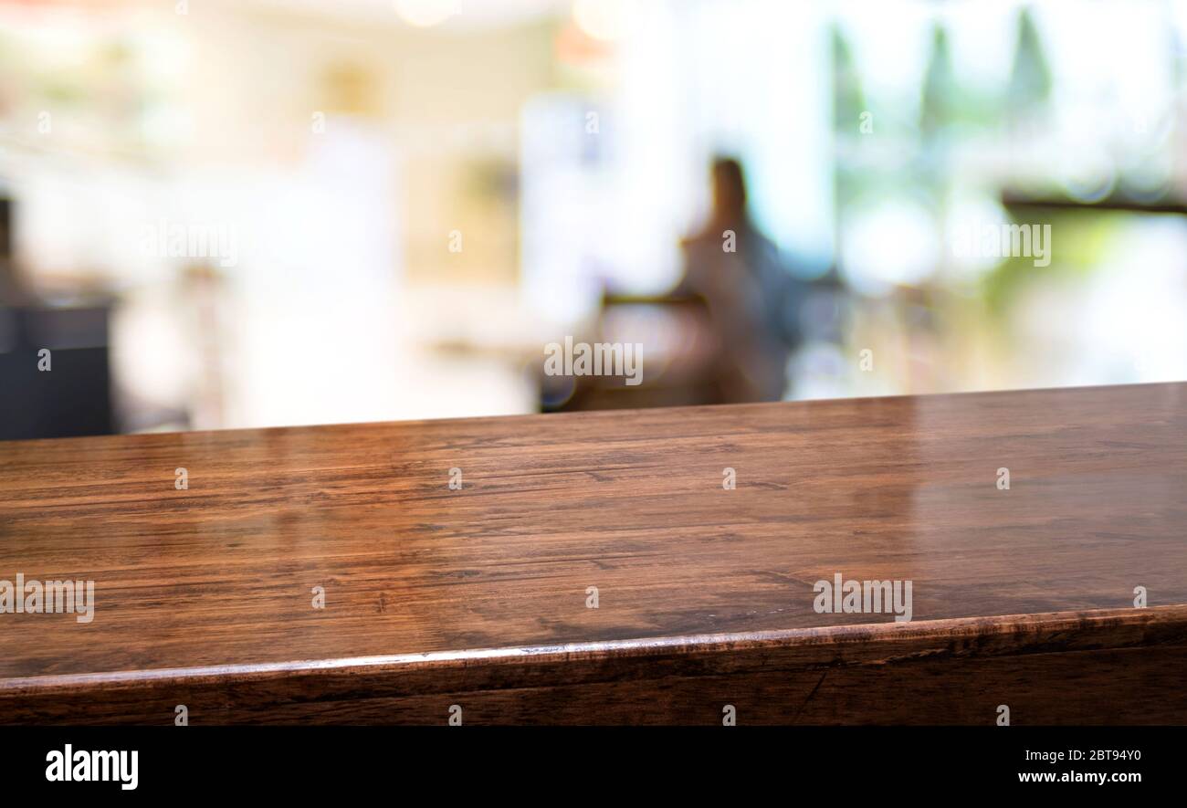 Tavolo diagonale in legno con cena al ristorante blur background.Empty prospettiva bar in legno duro con caffetteria blur con bokeh light, Mock up ba Foto Stock