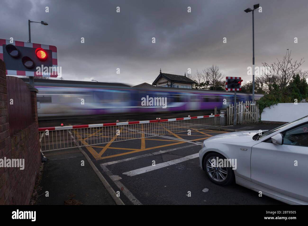 Auto in attesa di passaggio a livello Carleton, Blackpool come un treno velocità passato Foto Stock