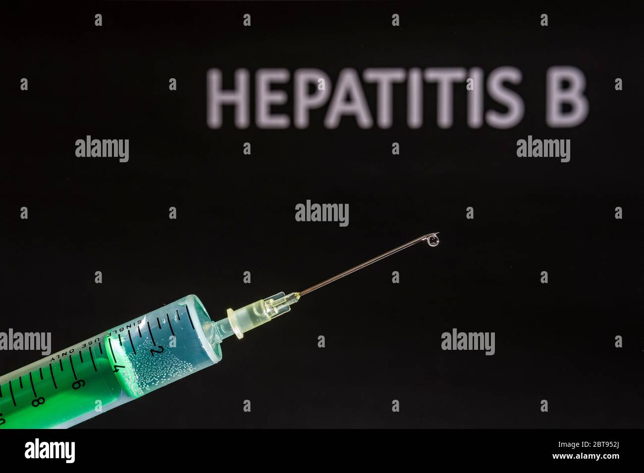 Questa figura mostra una siringa monouso con ago ipodermico, HEPATITIS B scritta su una lavagna nera dietro Foto Stock