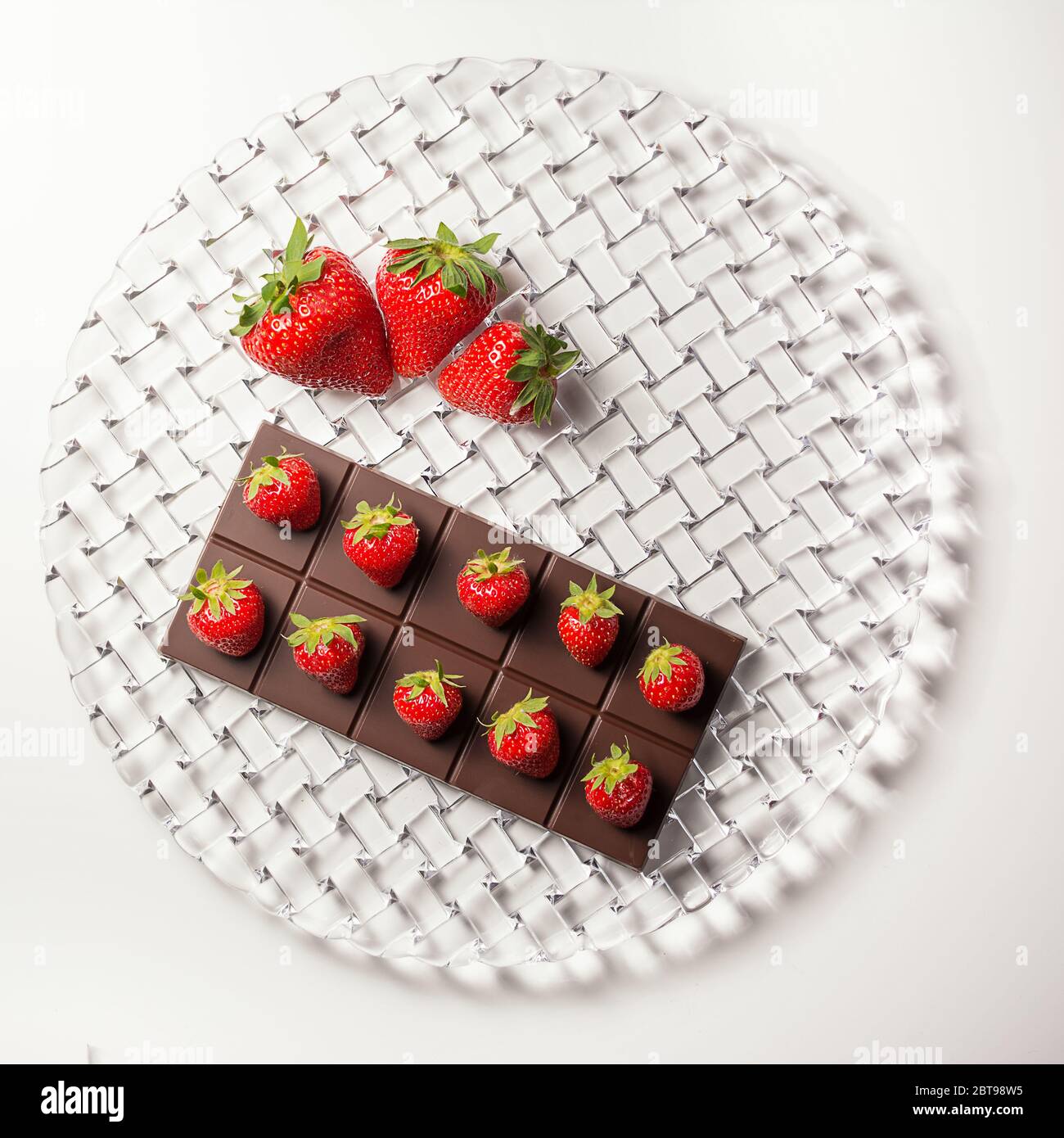 Una composizione della piastra con barretta di cioccolato e fragole sulla parte superiore e fragole grandi sul lato visto dall'alto Foto Stock