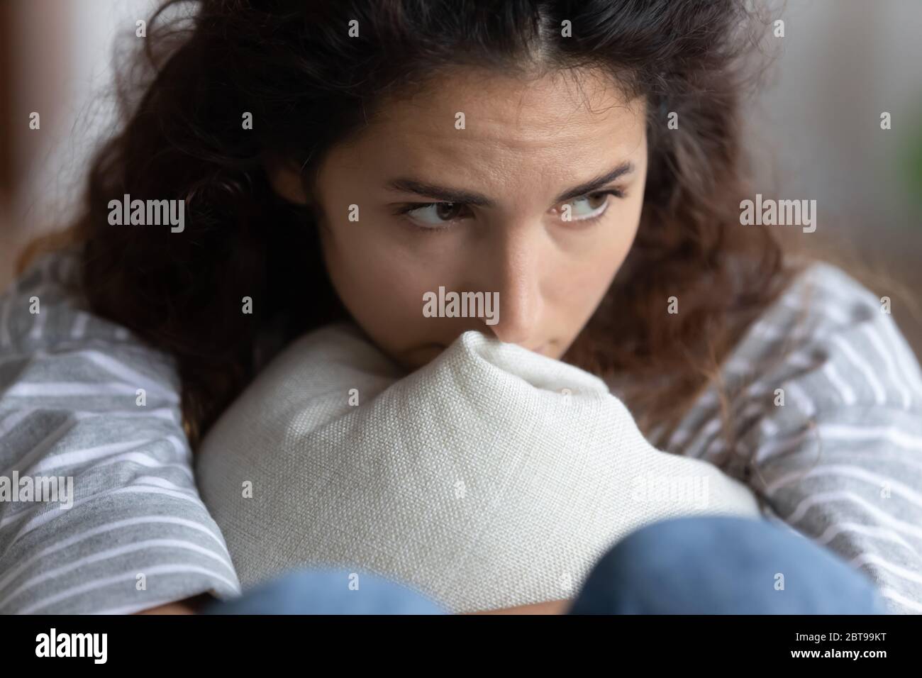 Primo piano su donna depressa infelice pensando a problemi, abbracciando cuscino Foto Stock