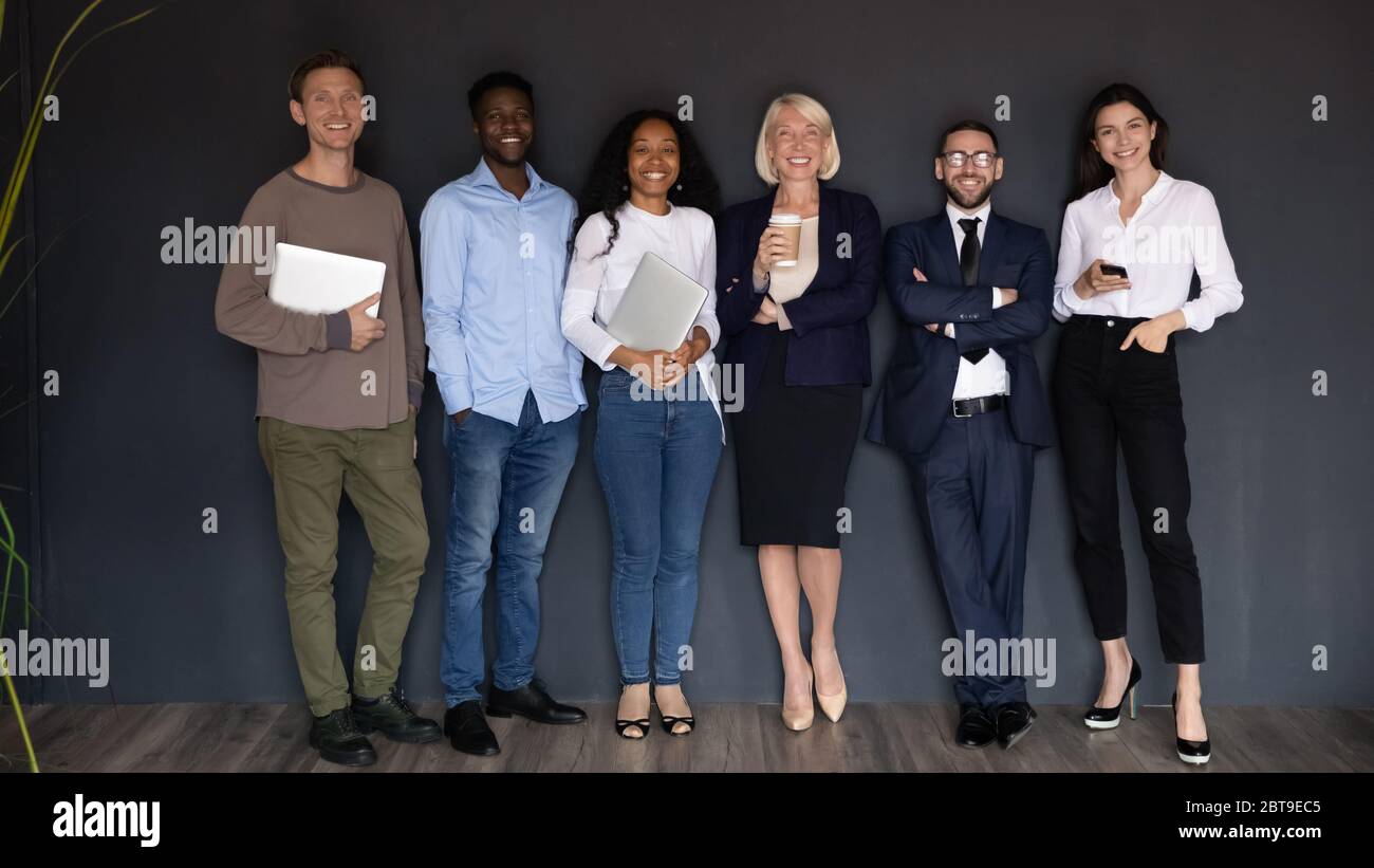 Sorridendo persone diverse di affari in fila su sfondo nero Foto Stock