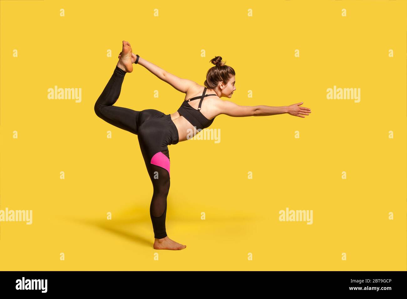 Posa ballerina. Donna sottile con capelli bun in stretto sport che pratica yoga, facendo Natarajasana esercizio su una gamba, allungando i muscoli e l'equilibrio. f Foto Stock
