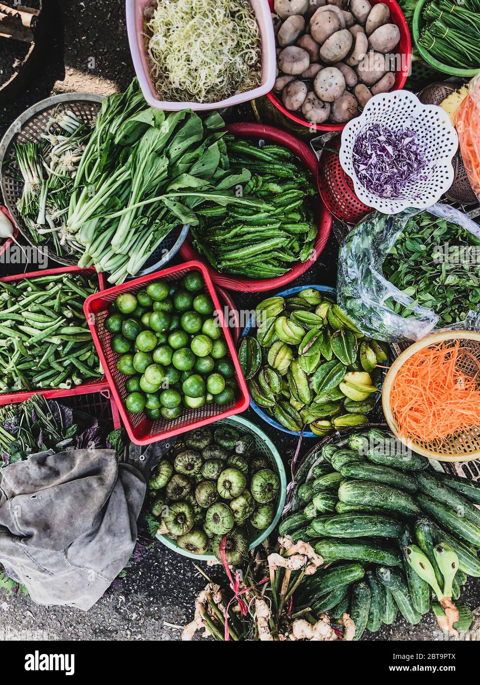 Vista dall'alto su un vasto assortimento di verdure sfuse e di frutta in fila in vendita in una strada. Produzione di cortocircuito presso il mercato di Hue Foto Stock
