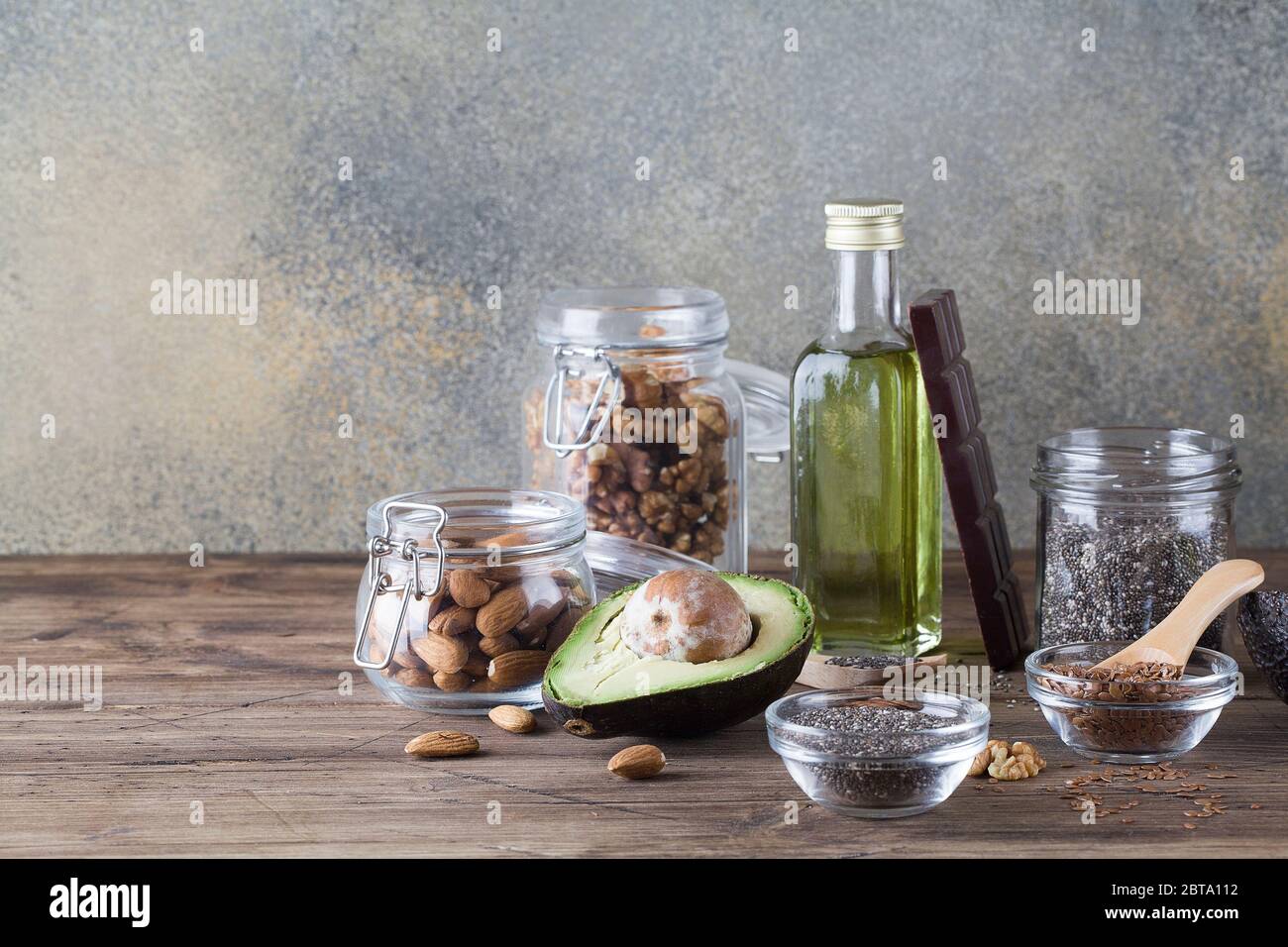 grassi sani fonti di frutti di lino olio di avocado chia semi e cioccolato amaro su sfondo scuro .sano cibo eco-friendly concetto, copia spazio Foto Stock