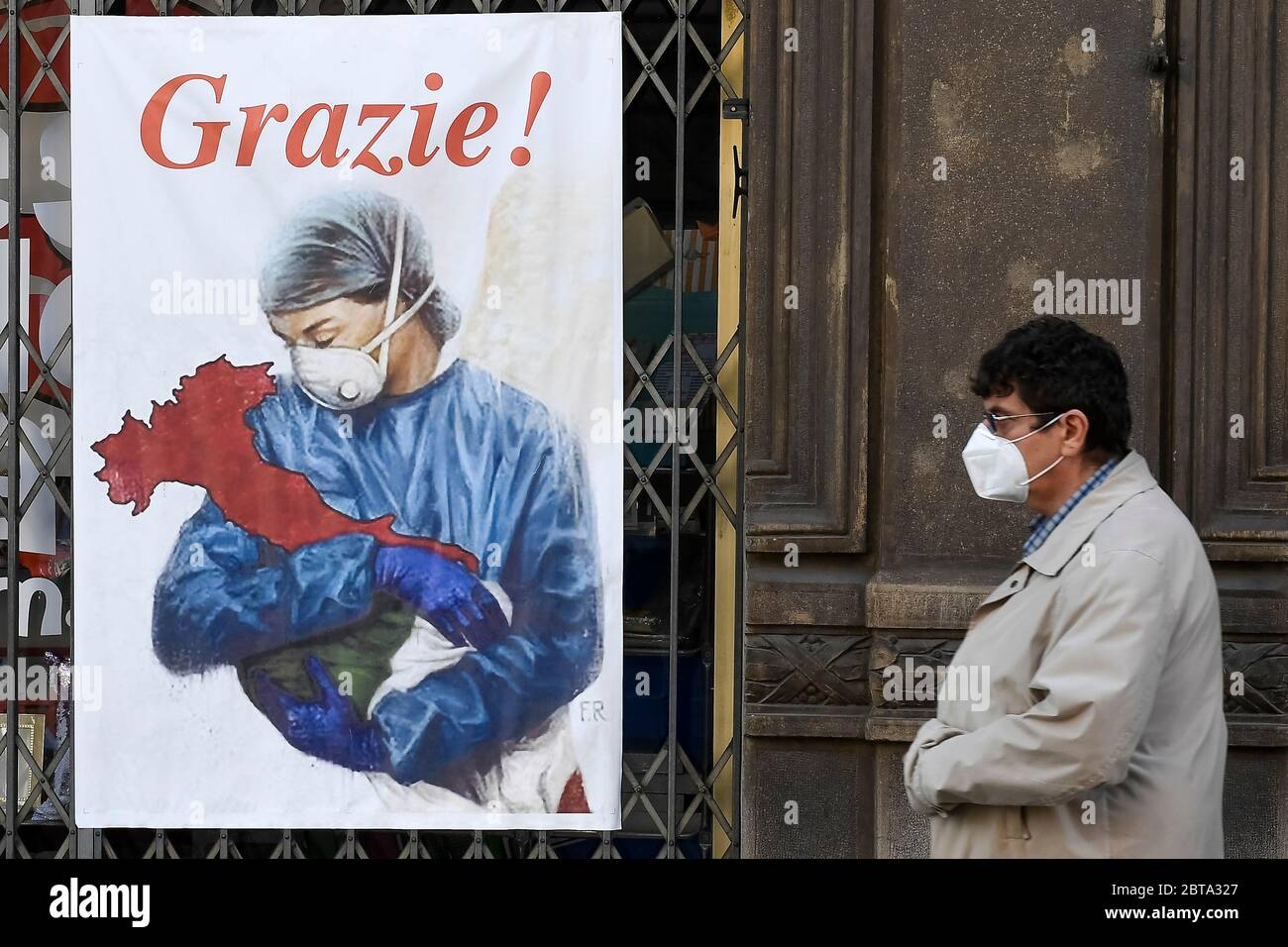 Torino, Italia - 22 aprile 2020: Un uomo cammina vicino a un banner per ringraziare gli operatori sanitari italiani. Il governo italiano ha imposto restrizioni senza precedenti per fermare la diffusione dell'epidemia di coronavirus COVID-19, tra le altre misure i movimenti di persone sono consentiti solo per lavoro, per l'acquisto di beni essenziali e per motivi di salute. Credit: Nicolò campo/Alamy Live News Foto Stock