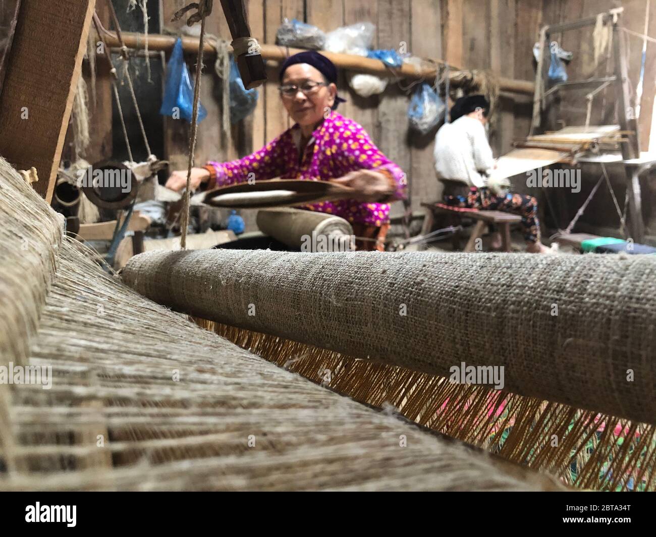 Lung Tam, Vietnam - 9 gennaio 2020 - la tessitura della donna in modo tradizionale, concentrarsi sulla lin e il telaio Foto Stock