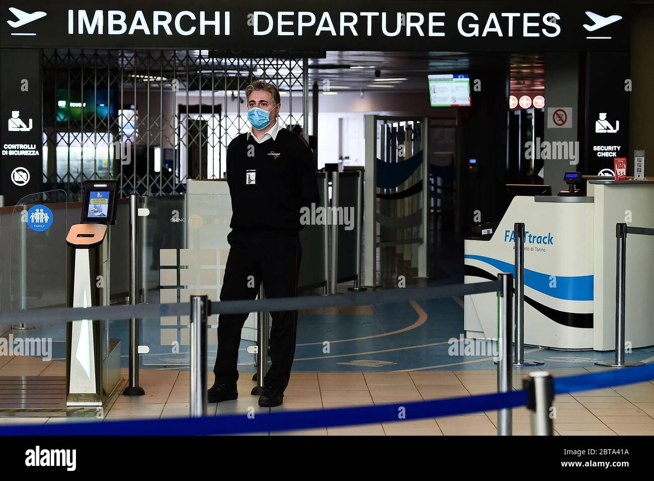 Torino - 02 aprile 2020: Un uomo che indossa una maschera respiratoria si trova di fronte alle porte di partenza dell'aeroporto di caselle. L'aeroporto di caselle è aperto ma la maggior parte dei voli sono cancellati. Il governo italiano ha imposto restrizioni senza precedenti per fermare la diffusione dell'epidemia di coronavirus COVID-19, tra le altre misure i movimenti di persone sono consentiti solo per lavoro, per l'acquisto di beni essenziali e per motivi di salute. Credit: Nicolò campo/Alamy Live News Foto Stock