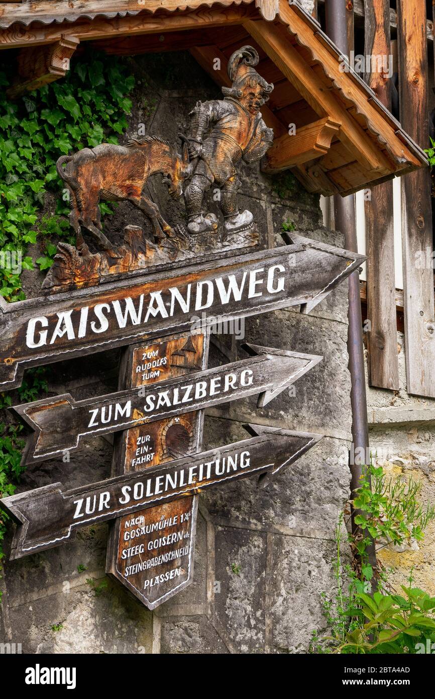 Legno scolpito segno posto che mostra la strada per il 'Gaiswandweg', per il 'Salzberg' e per il 'Solenleitung' in Hallstatt, Salzkammergut, OÖ, Austria Foto Stock