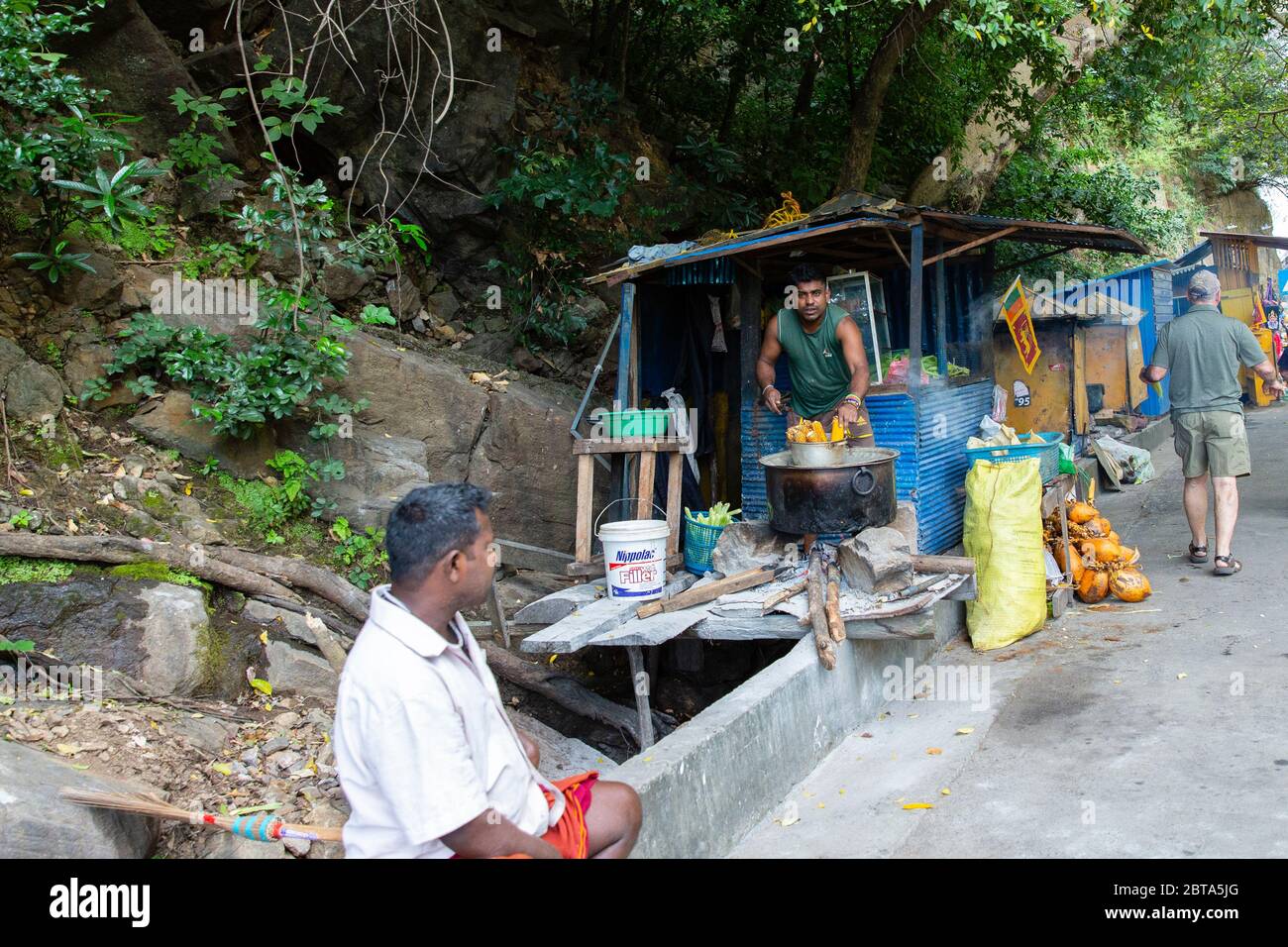 Preparazione di pannocchie in vendita in una destinazione turistica. Ravana Falls, Ella Gap, è una popolare attrazione turistica dello Sri Lanka. Attualmente è un'unica soluzione Foto Stock