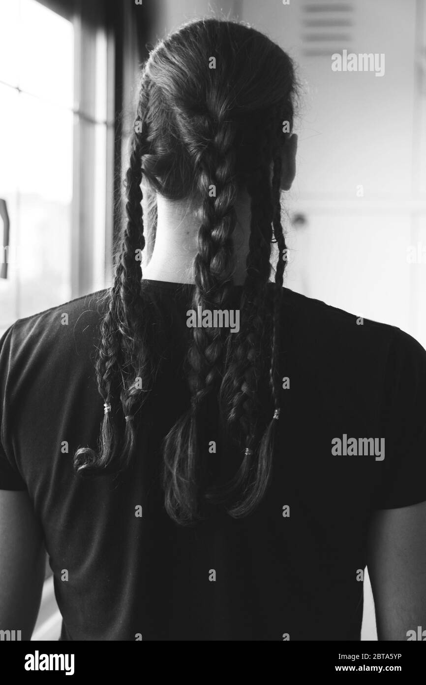 Modello maschio elegante con trecce in posa. Stile, acconciatura, concetto di moda. Foto Stock