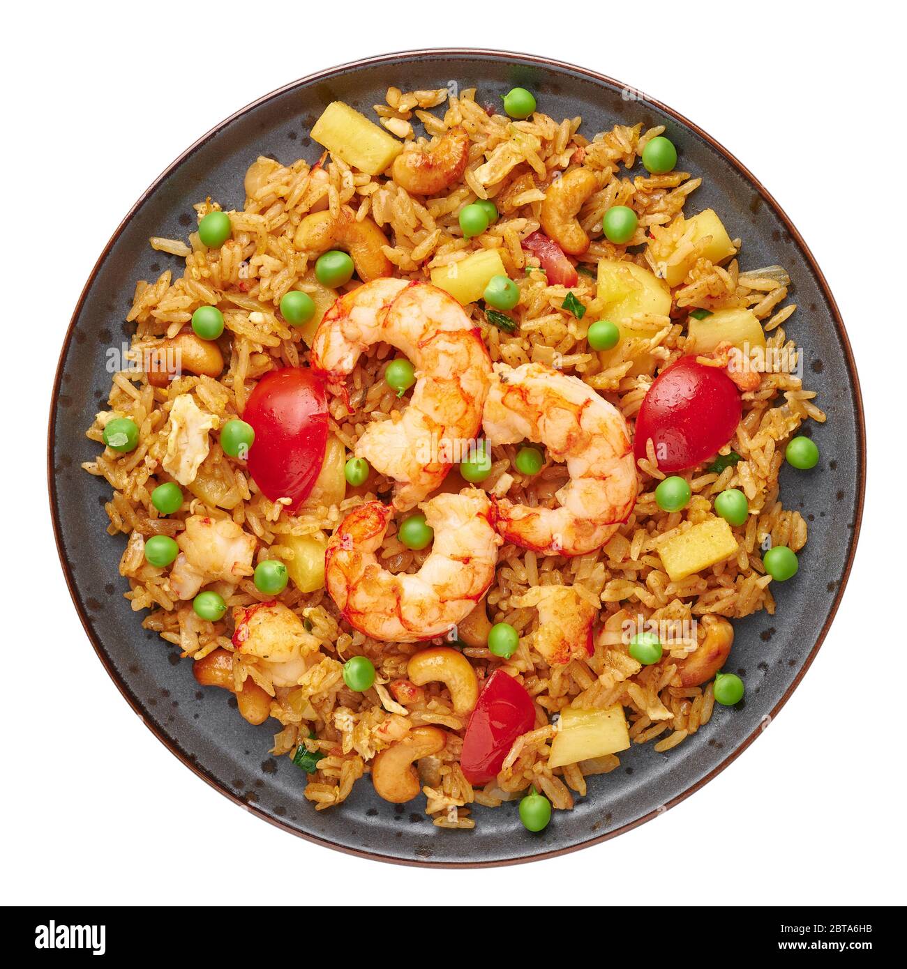 Riso fritto di ananas tailandese o Kao Pad Sapparod su un piatto nero isolato su sfondo bianco. Il Kao Pad Sapparod è un piatto di cucina tailandese. Pasto in Tailandia. ASI Foto Stock