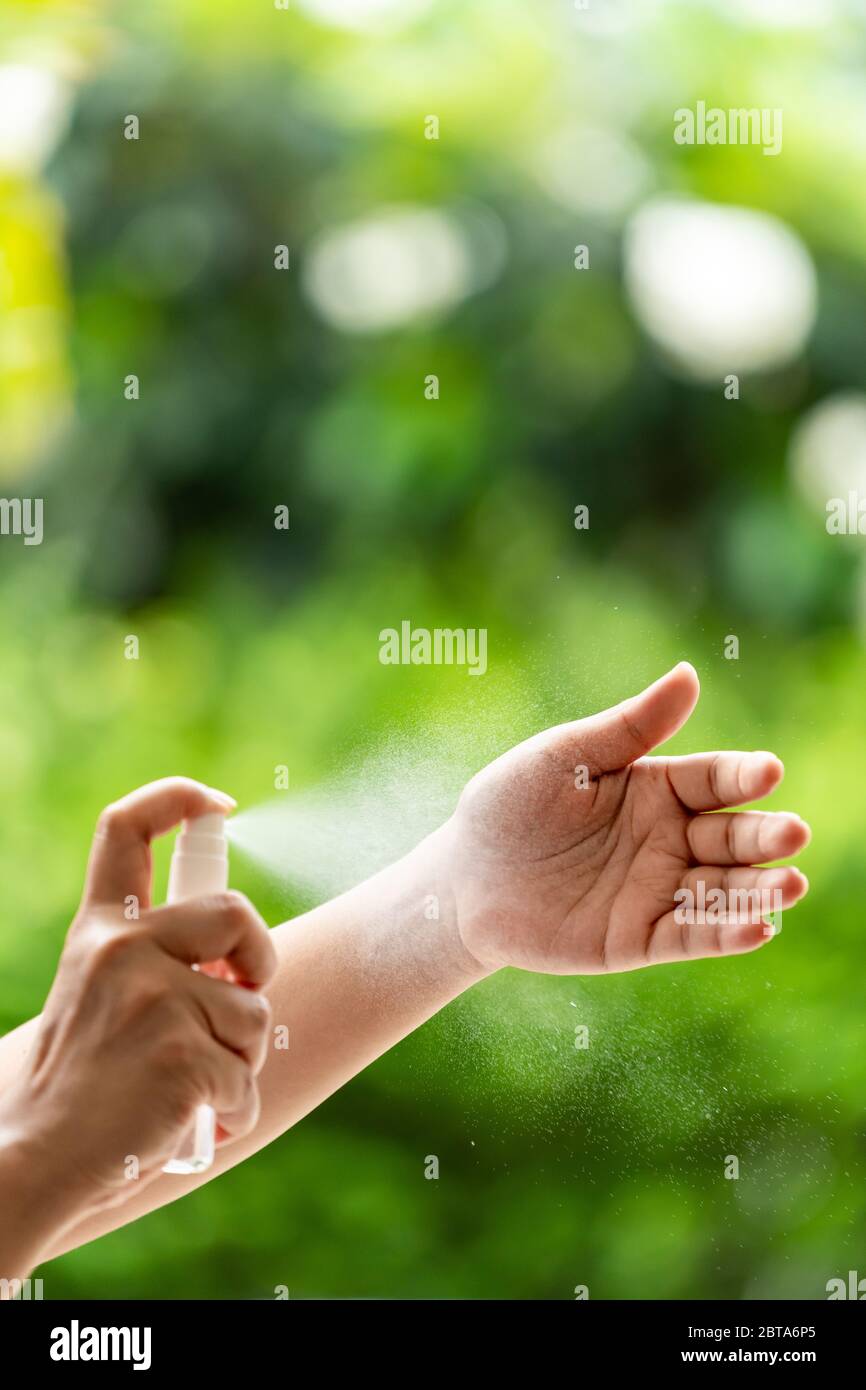 Pulizia a distanza ravvicinata della mano con disinfettante per mani a spruzzo con alocoolo, disinfezione per la sicurezza prevenire e proteggere dall'infezione del virus A. Foto Stock