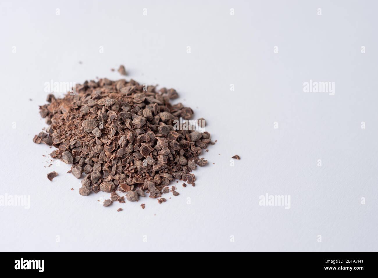 Granuli di cioccolato utilizzati per la produzione di cioccolato caldo su sfondo bianco visto lateralmente Foto Stock