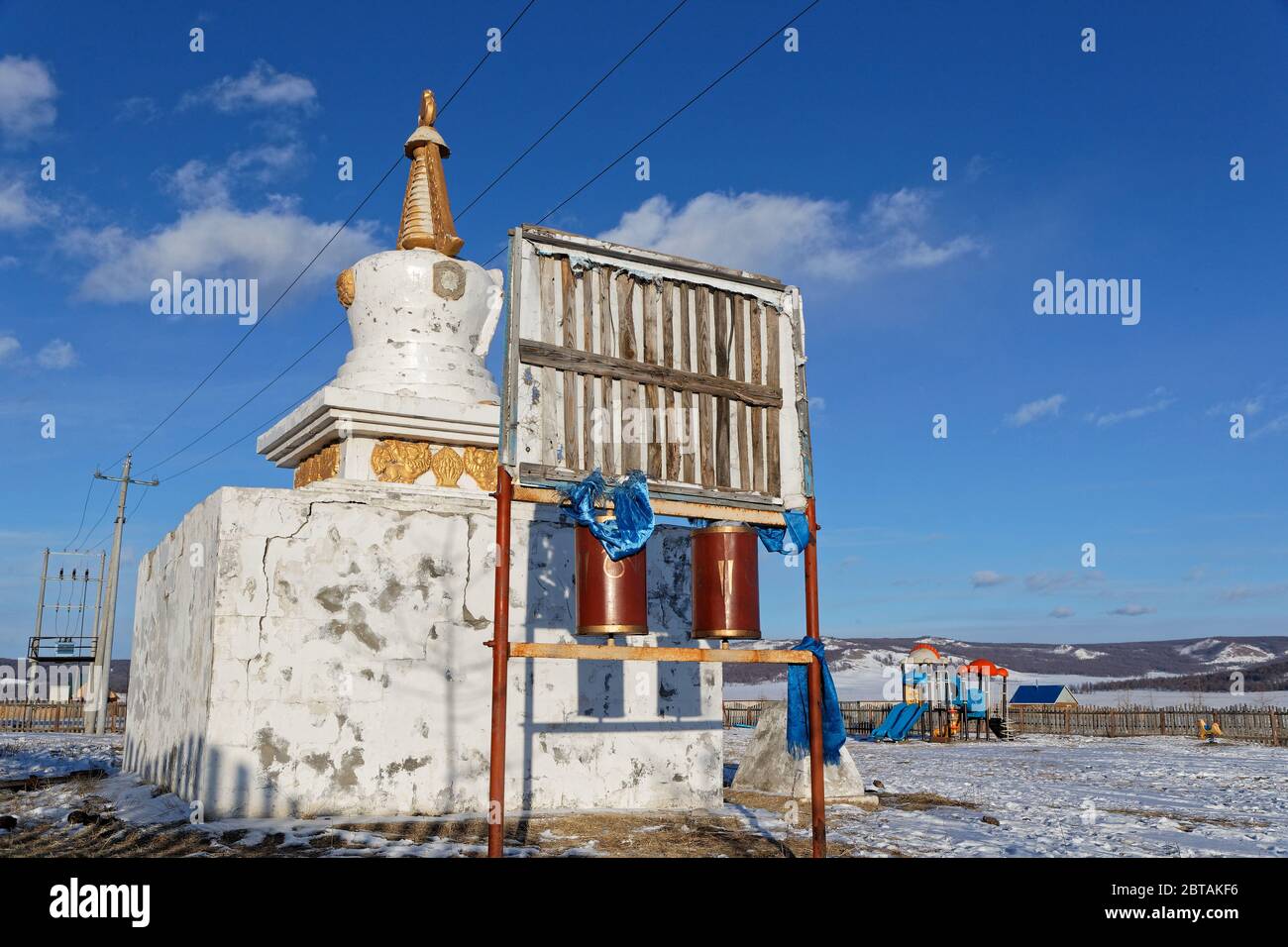 KHATGAL, MONGOLIA, 1 marzo 2020 : uno stupa bianco e ruote di preghiera nel cortile della scuola del villaggio. Foto Stock