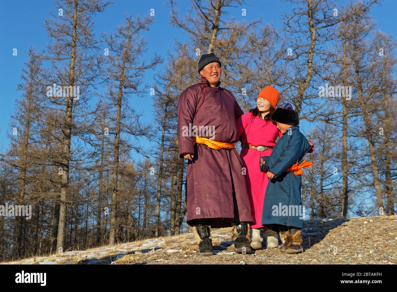 KHATGAL, MONGOLIA, 2 marzo 2020 : la gente mongolo, vestita con abiti tradizionali, posa in un paesaggio di foresta. Foto Stock