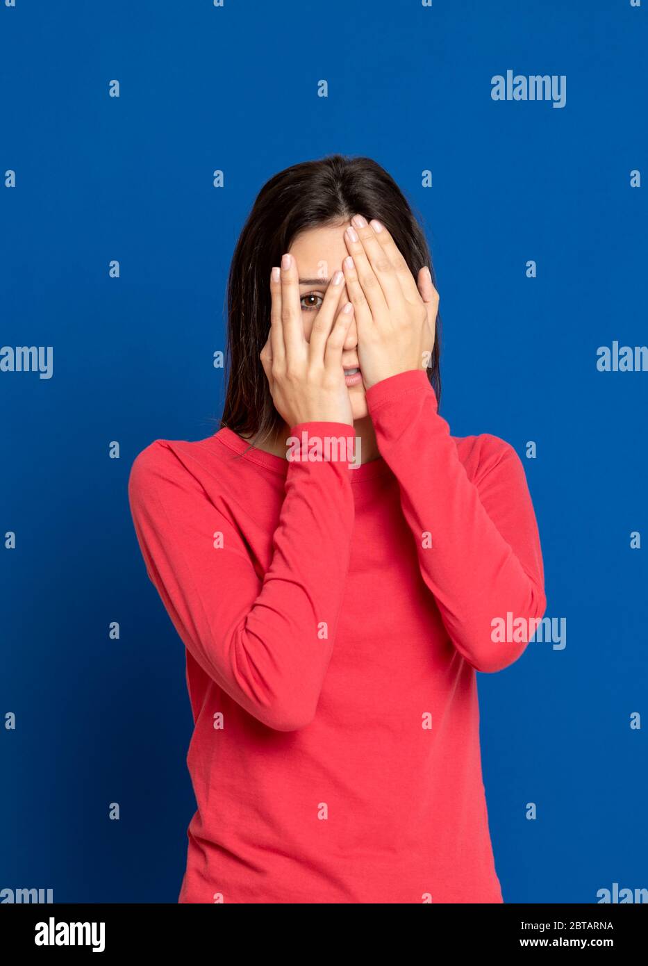 Bella ragazza brunette in studio su sfondo blu Foto Stock