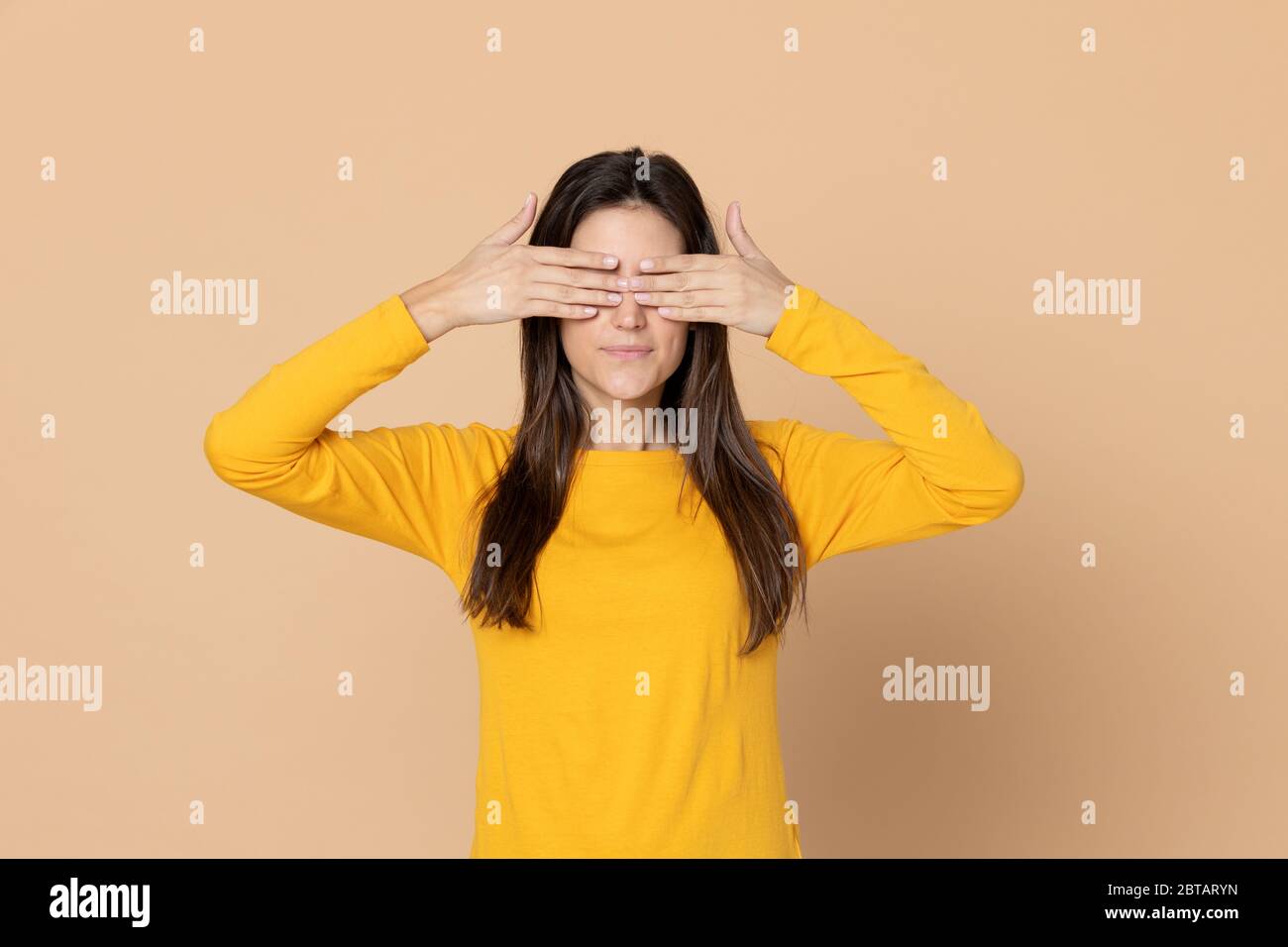 Ragazza giovane attraente che indossa una T-shirt su sfondo giallo Foto Stock