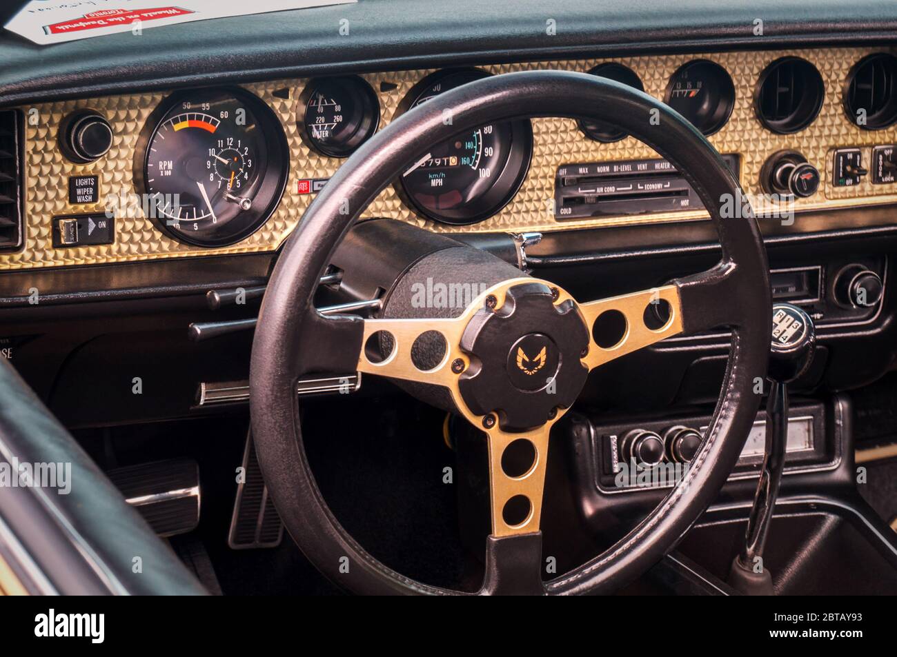 TORONTO, CANADA - 08 18 2018: Volante con logo, quadranti e manopole sul pannello anteriore dorato di 1979 Pontiac Firebird Trans am T-top auto con timer Foto Stock