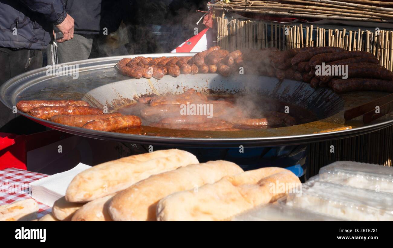 Vendita di salsicce in panini caldi per cani sulla strada. Salsicce su piastra riscaldante Commercial Griddle. Foto Stock