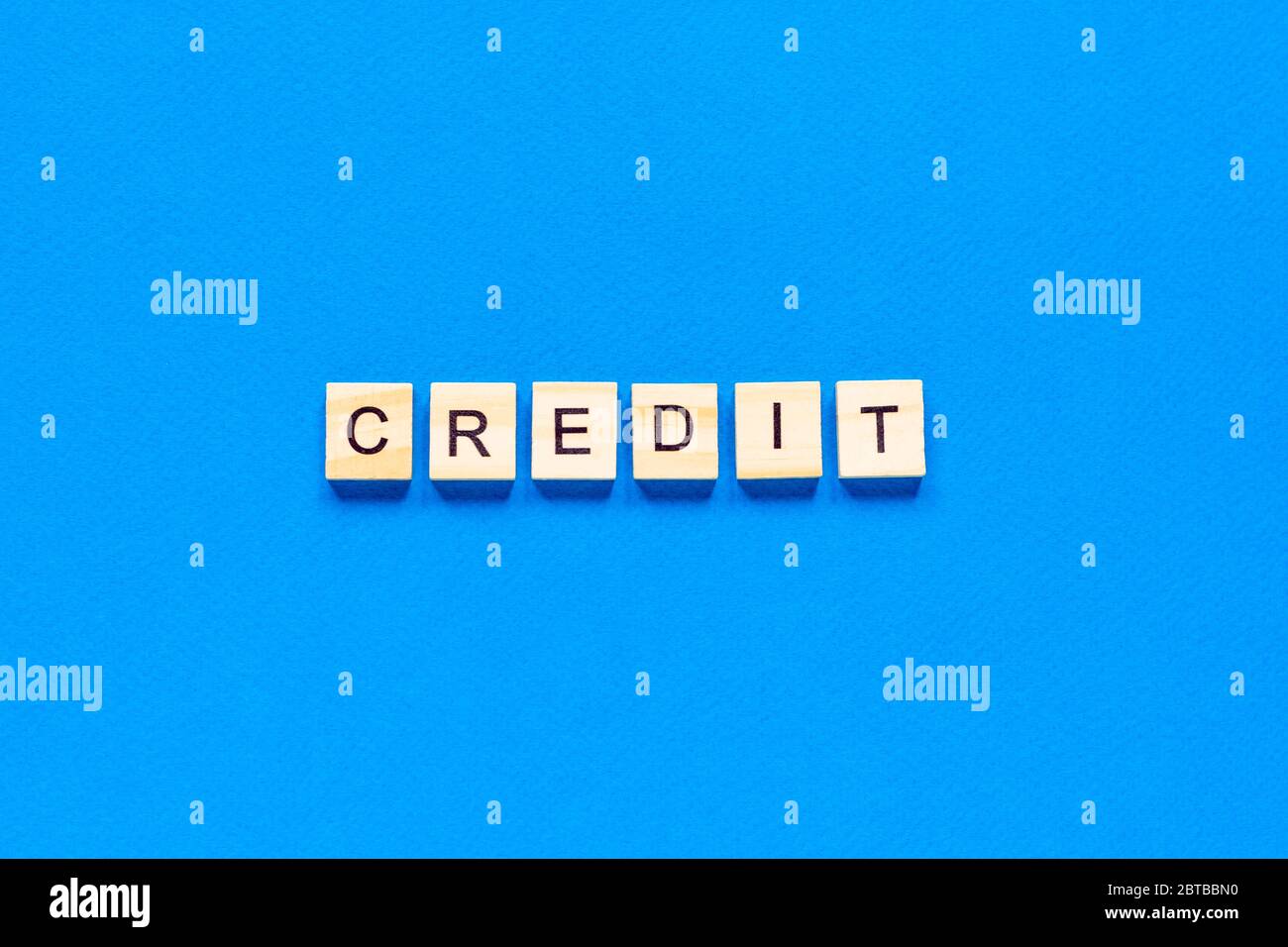 iscrizione di credito in lettere di legno su sfondo blu, disposizione piatta, vista dall'alto, classico colore blu Foto Stock