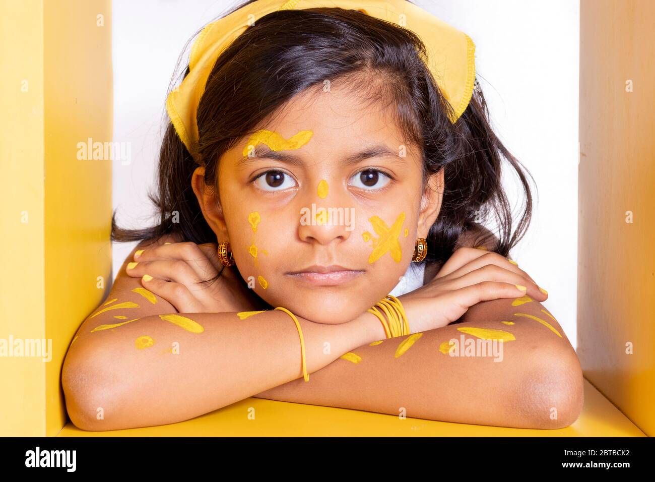 Felice bambina, con il suo volto dipinto per celebrare il giorno giallo Foto Stock