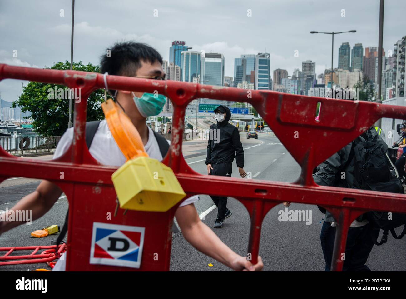 Un protester costruisce barricate per bloccare il traffico durante le dimostrazioni contro il progetto di legge. La polizia di Hong Kong ha sparato gas di lacrima e pepe spray sui dimostranti dopo che migliaia di persone sono scese per le strade di Causeway Bay protestando contro Pechino? dichiarazione che intende imporre le leggi nazionali in materia di sicurezza. Foto Stock