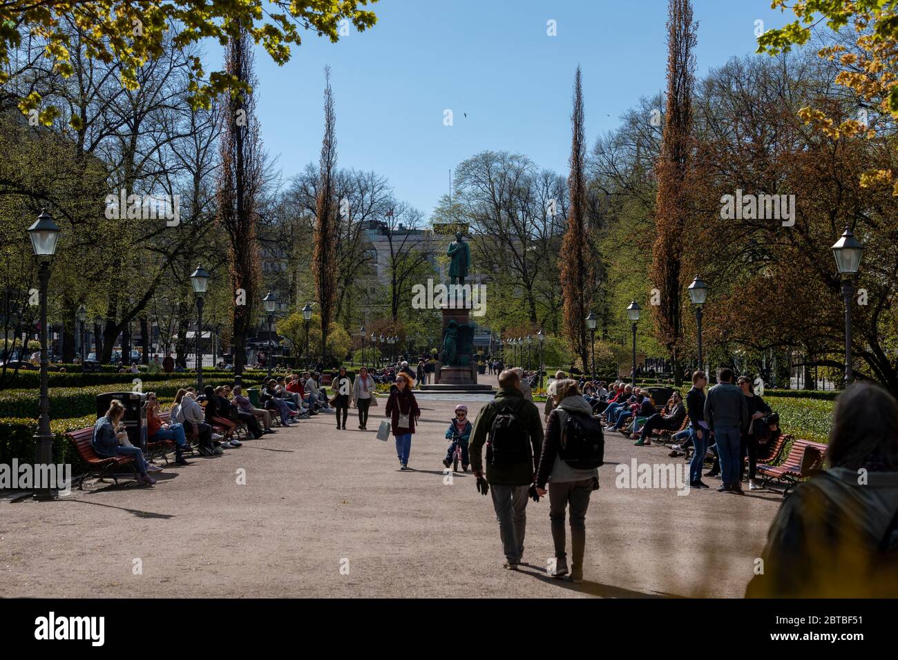 Le prime calde giornate primaverili fanno sì che le persone si ritrovino all'aperto nei parchi pubblici del centro di Helsinki. Tuttavia, si sta applicando la distanza sociale. Foto Stock