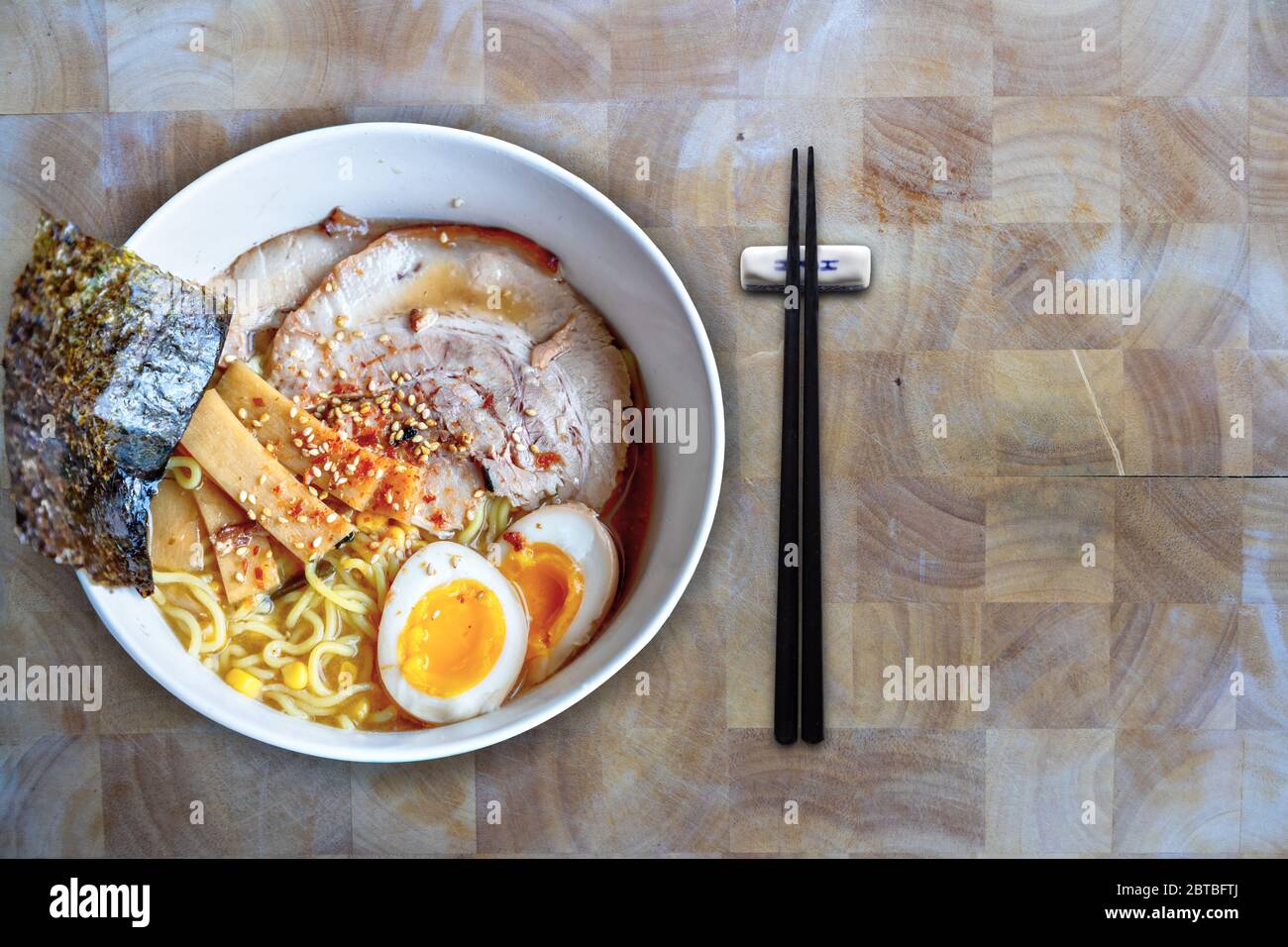 Ciotola di ramen di Hokkaido in una ricca zuppa di miso con zuppa di maiale giapponese o char Siu fatta in casa, uova di tuorlo, germogli di bambù, alghe marine e sesamo Foto Stock