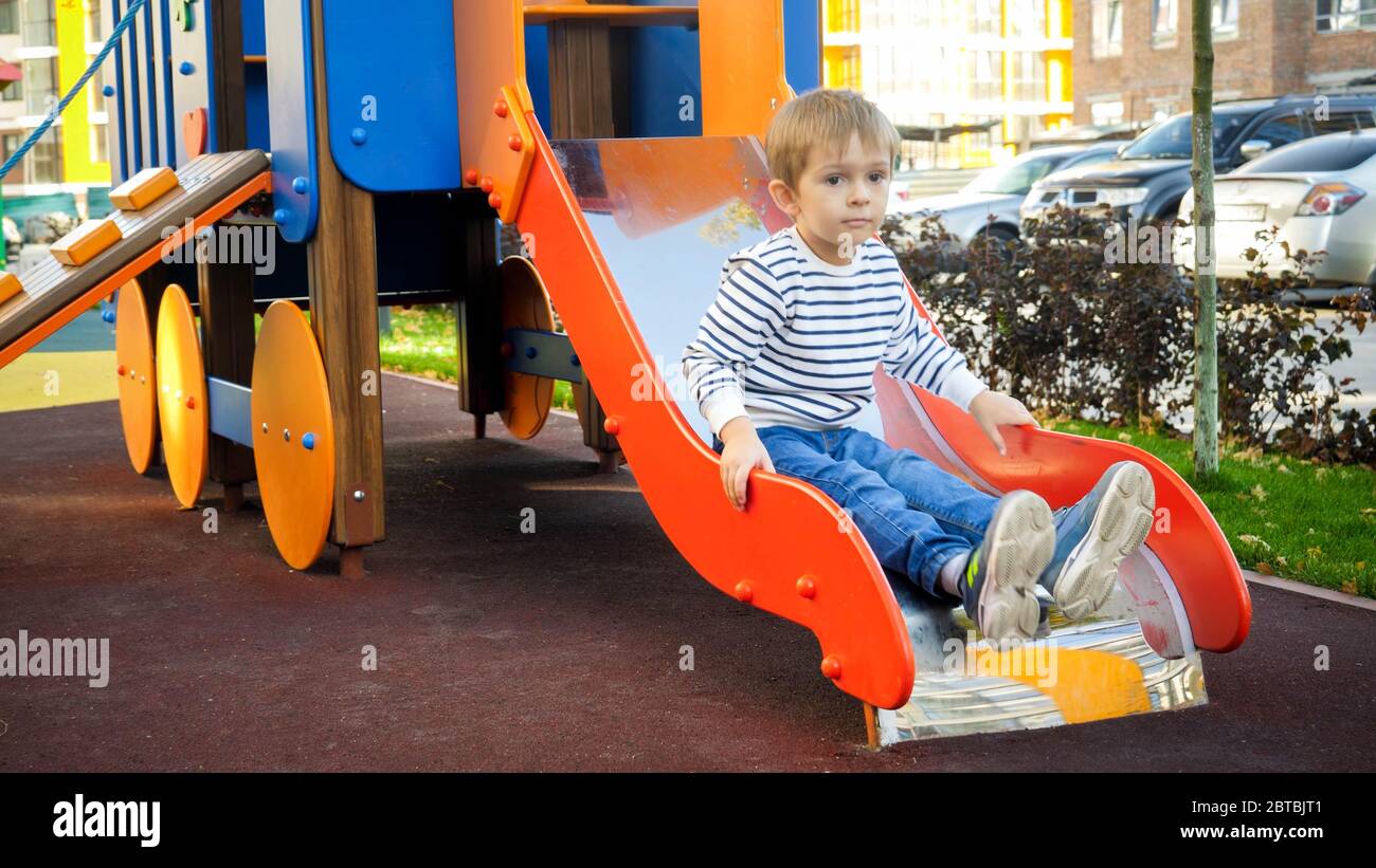 Bambino sconvolto seduto sullo scivolo nel parco giochi per bambini Foto  stock - Alamy