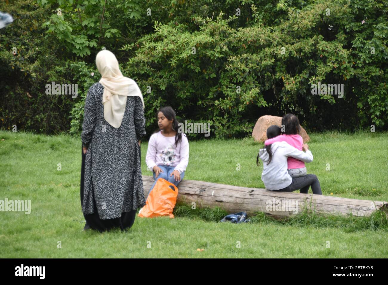Donna asiatica con bambini nel parco Foto Stock