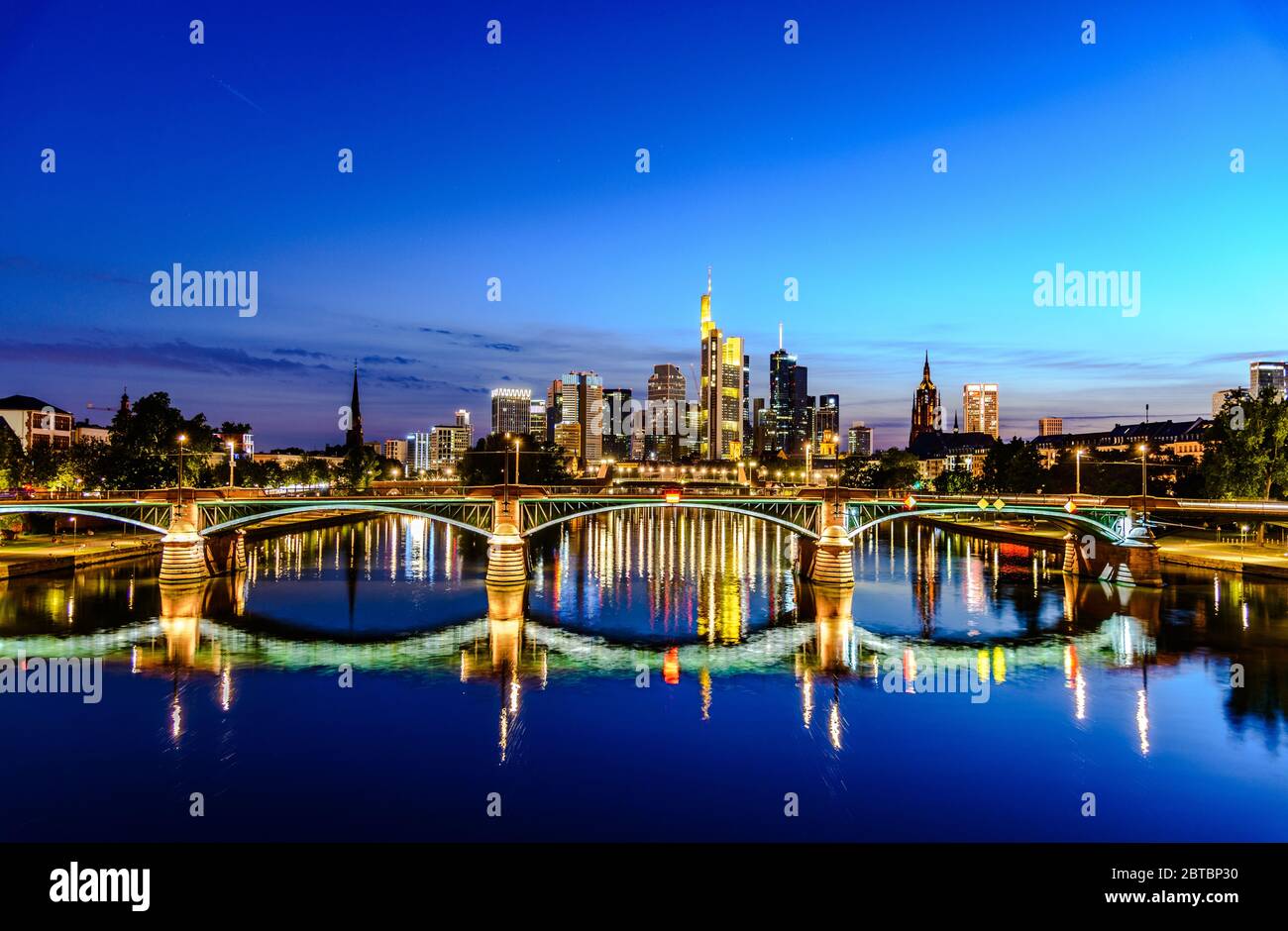 Splendida vista sullo skyline cittadino del centro di Francoforte sul meno, ponte con luci durante il tramonto all'ora blu, sera e notte. Finanza europea Foto Stock