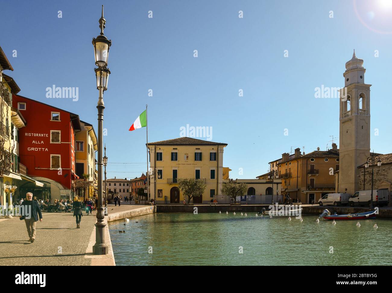 Vista retroilluminata del centro storico della città vecchia sulla riva del Lago di Garda con il porticciolo e il municipio, Lazise, Verona, Veneto, Italia Foto Stock