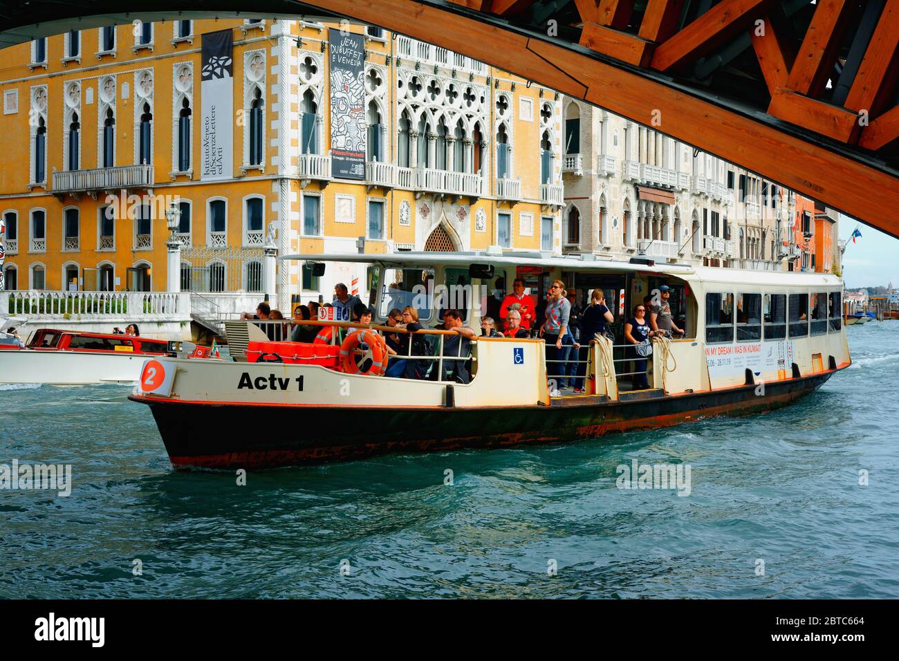 Vaporetto che passa sotto il Ponte dell'Accademia accanto a Palazzo cavalli-Franchetti a Venezia Foto Stock