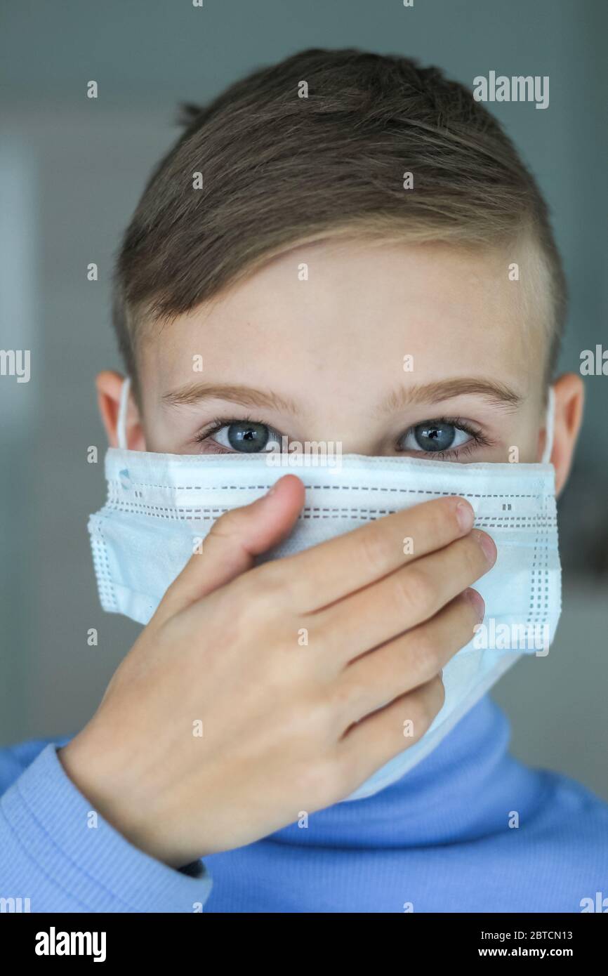 Il bambino si mette su una maschera protettiva Foto Stock
