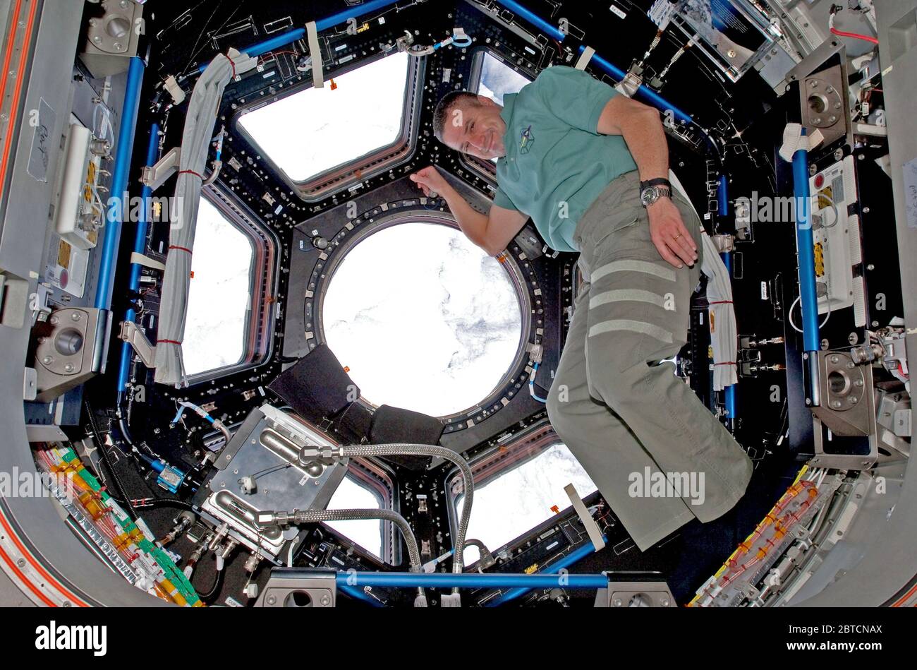 2010 - STS-130 il comandante George Zamka in posa per una foto della Cupola durante la spedizione 22 / STS-130 operazioni congiunte. Foto Stock